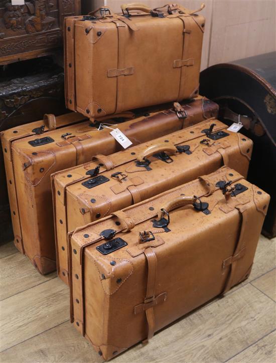 A stack of four pigskin suitcases, Largest W.75cm